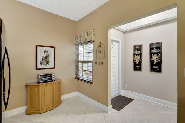 tiled entryway with a textured ceiling