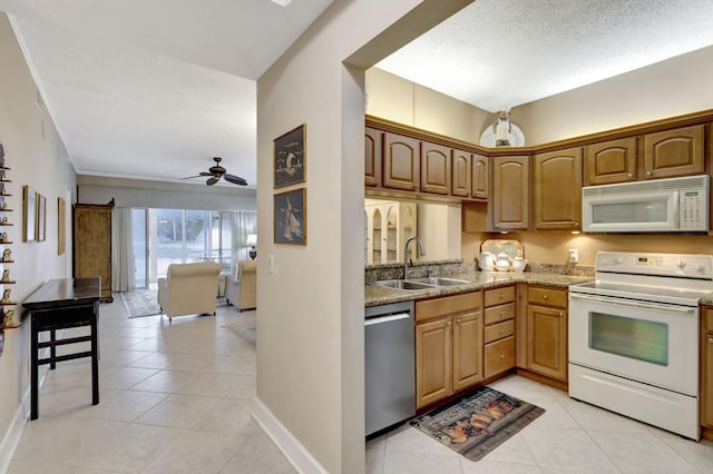 kitchen with white appliances, a textured ceiling, ceiling fan, sink, and light tile patterned floors