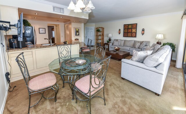 dining space with carpet, crown molding, a notable chandelier, and sink