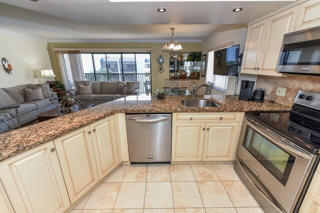 kitchen featuring stainless steel appliances, an inviting chandelier, tasteful backsplash, kitchen peninsula, and stone countertops