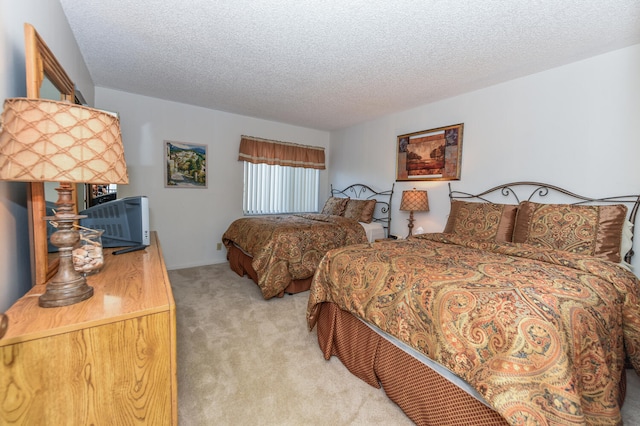 bedroom featuring a textured ceiling and light carpet