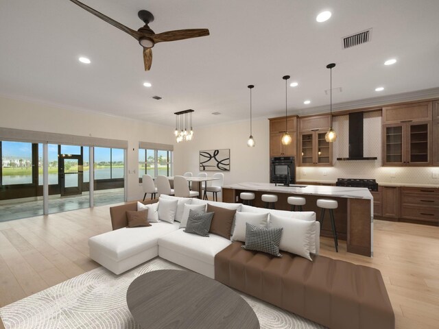 living room featuring a water view, ceiling fan, ornamental molding, and light hardwood / wood-style floors