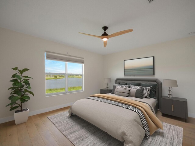 bedroom featuring a water view, ceiling fan, and light hardwood / wood-style floors