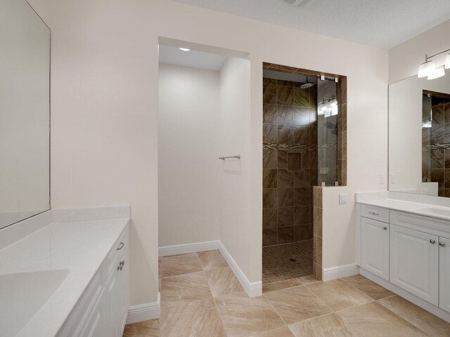 bathroom with vanity and tiled shower