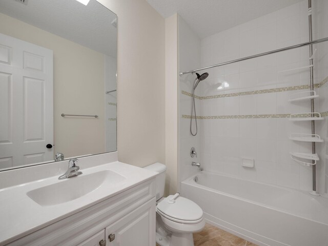 full bathroom featuring tiled shower / bath combo, tile patterned flooring, a textured ceiling, toilet, and vanity