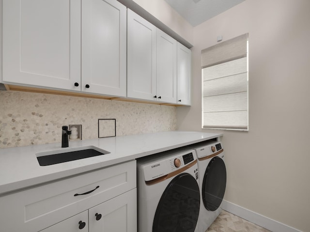 laundry room featuring cabinets, washer and clothes dryer, and sink