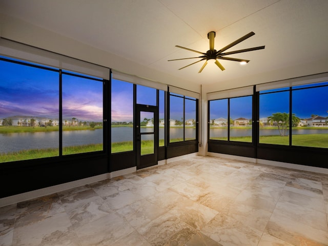 unfurnished sunroom featuring a water view and ceiling fan