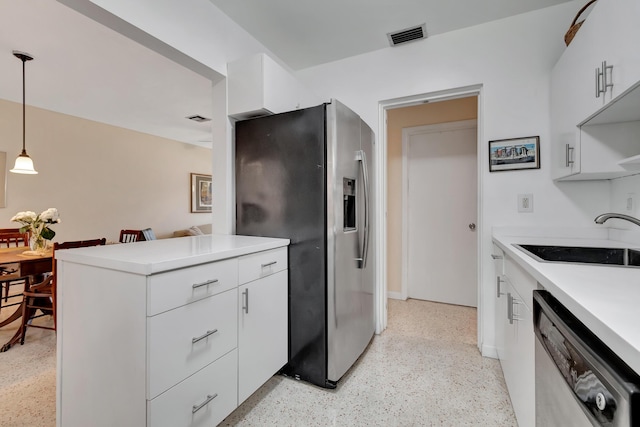 kitchen with white cabinets, decorative light fixtures, and stainless steel appliances