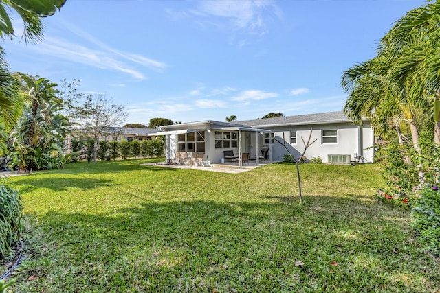 rear view of house with a patio, central AC unit, and a lawn