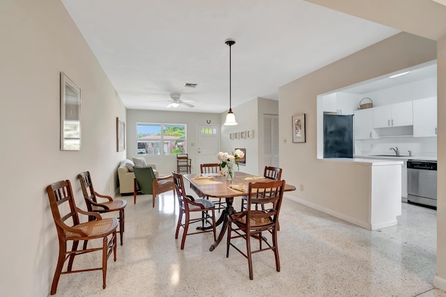 dining room featuring ceiling fan and sink