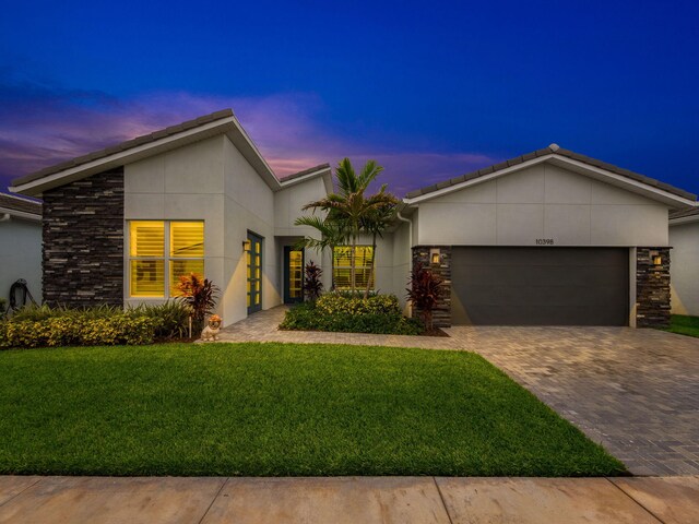 view of front of home with a garage and a yard