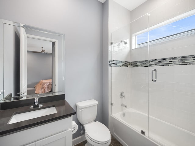 full bathroom featuring ceiling fan, vanity, bath / shower combo with glass door, and toilet