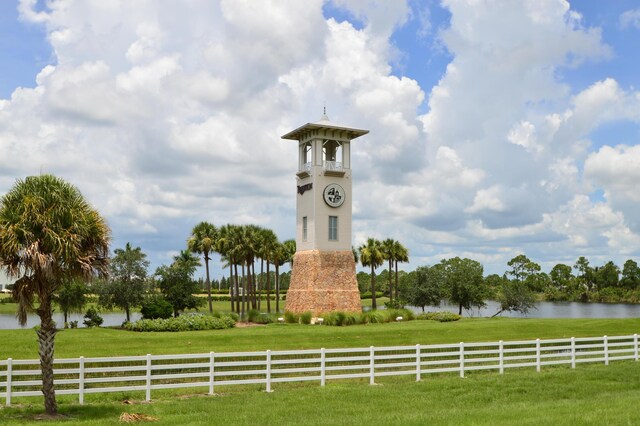 view of property's community featuring a rural view, a water view, and a lawn