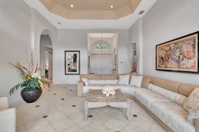 living room with a raised ceiling and a towering ceiling