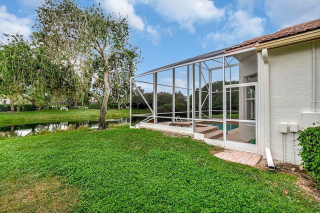 view of yard featuring a lanai and a water view