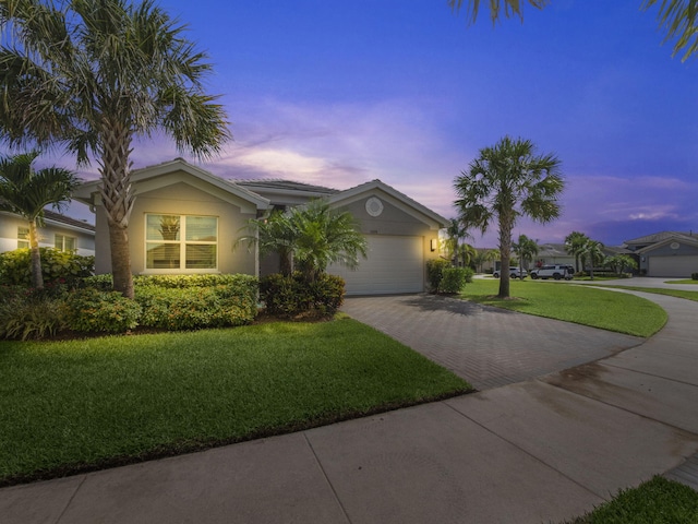 view of front of property with a garage and a yard