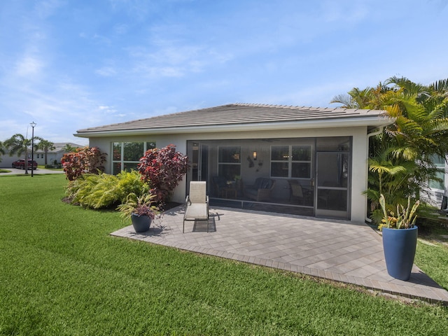 rear view of house featuring a patio and a lawn