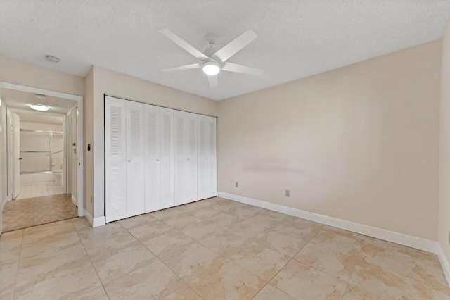 unfurnished bedroom featuring ceiling fan, light tile patterned floors, a textured ceiling, and a closet