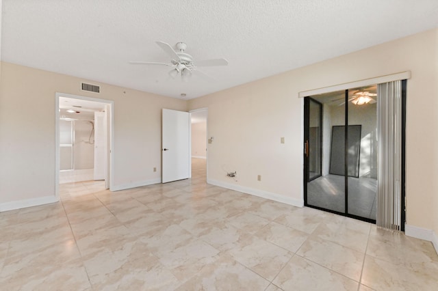 empty room with ceiling fan and a textured ceiling