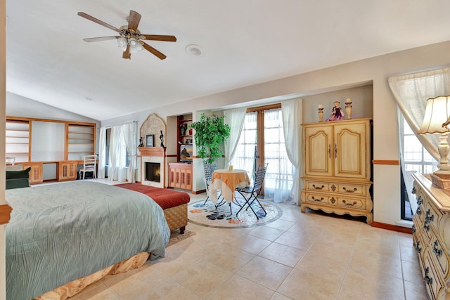 tiled bedroom featuring lofted ceiling, french doors, a large fireplace, and ceiling fan