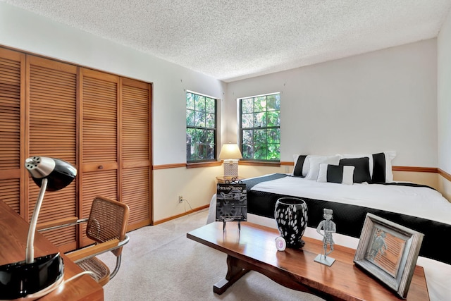 carpeted bedroom with a textured ceiling and a closet