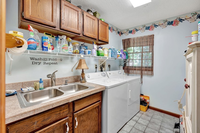 laundry area with cabinets, sink, a textured ceiling, and washing machine and dryer