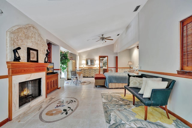 bedroom with ceiling fan, light tile patterned floors, a high end fireplace, and lofted ceiling