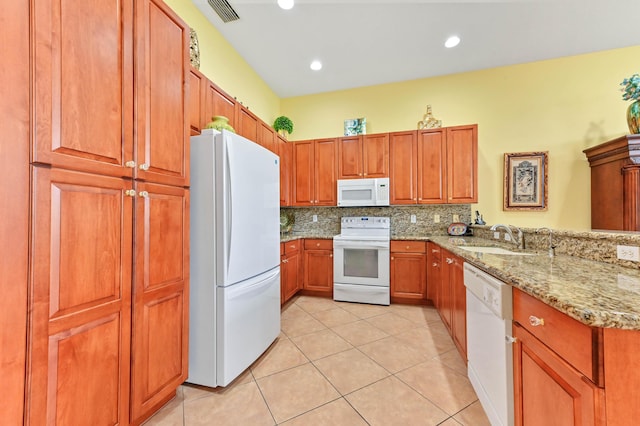 kitchen featuring white appliances, sink, decorative backsplash, light tile patterned floors, and light stone counters