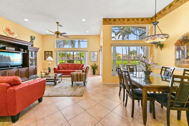 tiled dining area featuring a high ceiling and ceiling fan