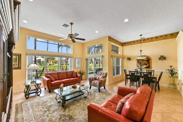 living room with light tile patterned floors, a textured ceiling, and ceiling fan