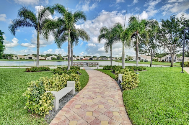 view of community with a yard and a water view