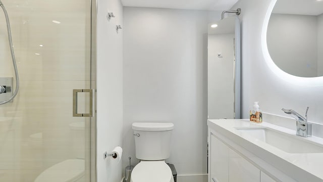 bathroom featuring a shower with door, vanity, and toilet