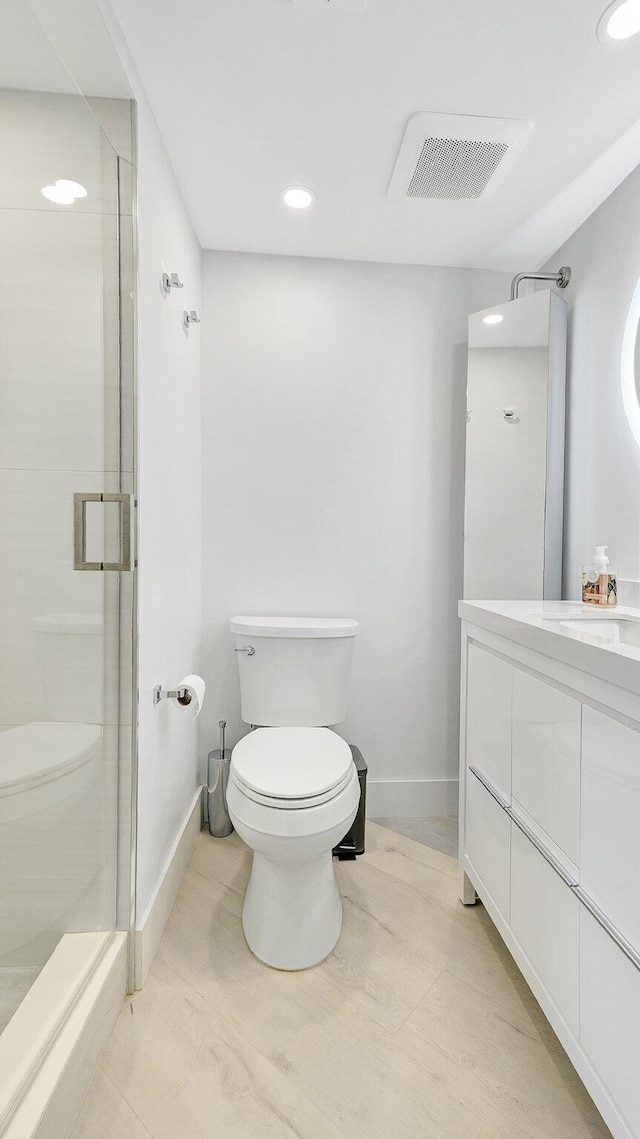 bathroom with vanity, toilet, and an enclosed shower