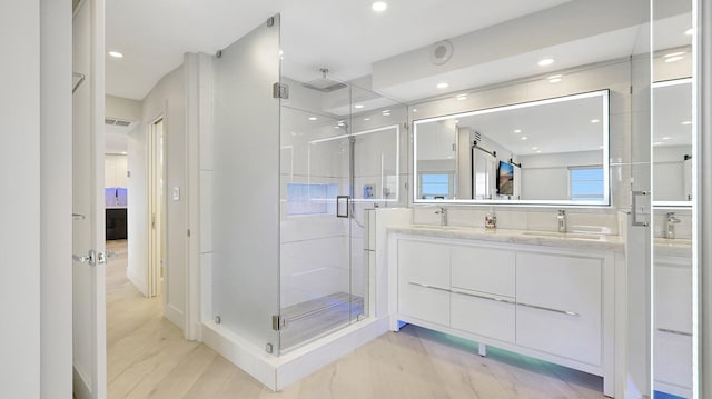 bathroom featuring hardwood / wood-style floors, vanity, and walk in shower