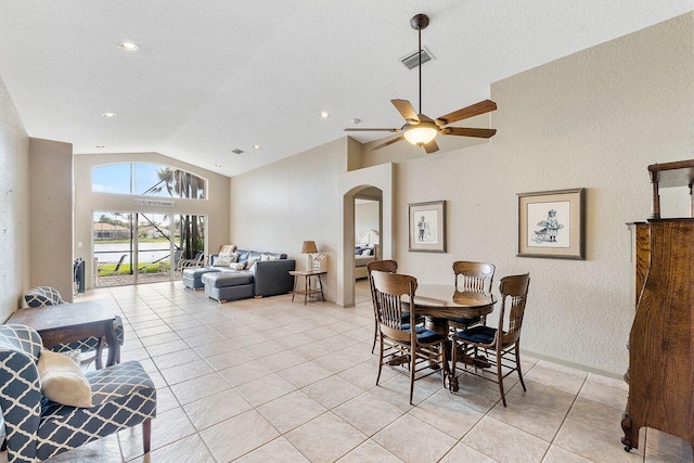 dining space featuring ceiling fan, light tile patterned flooring, a textured ceiling, and high vaulted ceiling