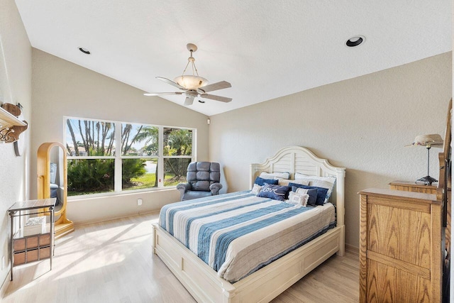 bedroom featuring ceiling fan, light hardwood / wood-style flooring, and lofted ceiling