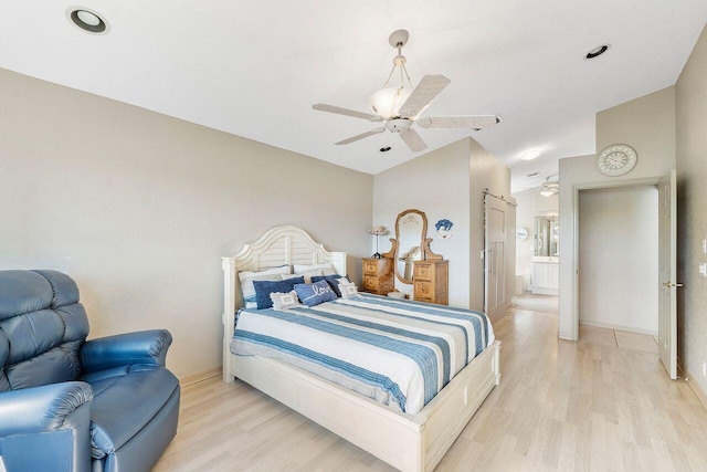 bedroom featuring ceiling fan, light hardwood / wood-style flooring, and ensuite bath