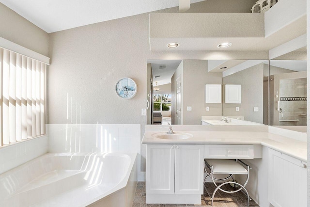 bathroom with vanity, a tub to relax in, and a healthy amount of sunlight