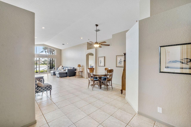 tiled dining space with high vaulted ceiling and ceiling fan