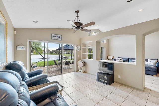 tiled living room with a textured ceiling, built in shelves, ceiling fan, and vaulted ceiling