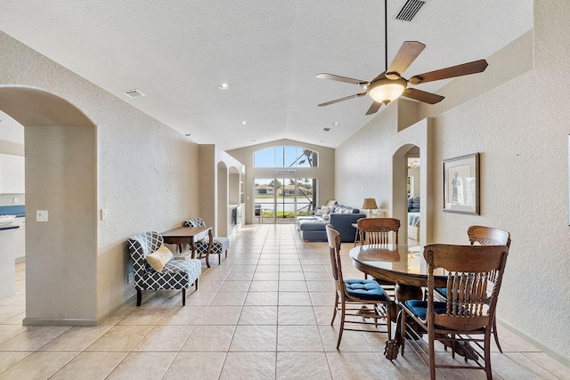 tiled dining space with a textured ceiling, ceiling fan, and lofted ceiling