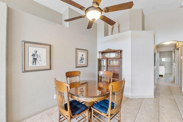 tiled dining area featuring high vaulted ceiling and ceiling fan