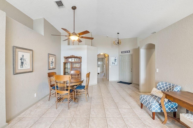 dining area with ceiling fan, light tile patterned floors, a textured ceiling, and high vaulted ceiling