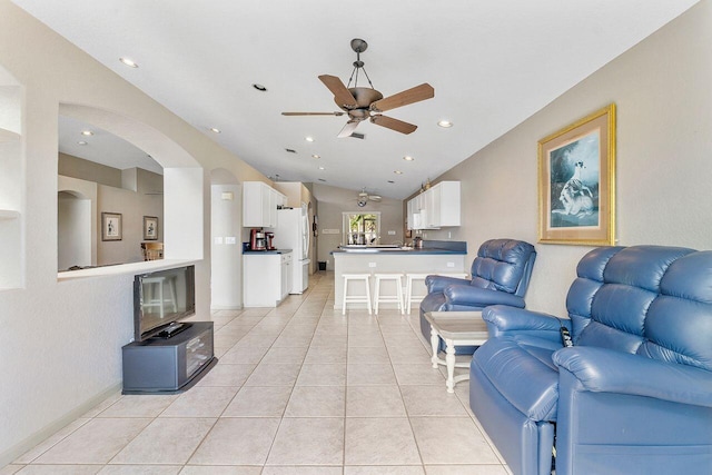 tiled living room featuring ceiling fan and lofted ceiling