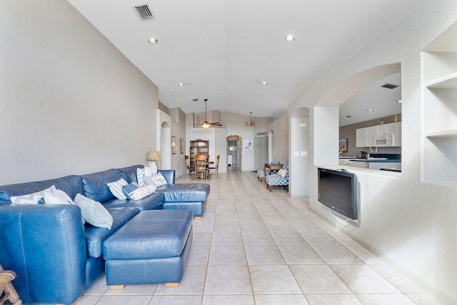 living room with ceiling fan, light tile patterned flooring, and lofted ceiling