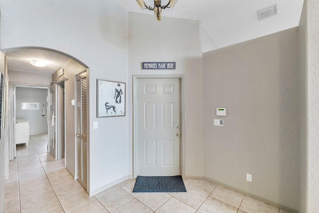 foyer featuring a textured ceiling and light tile patterned flooring