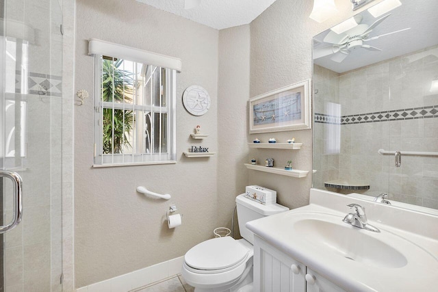 bathroom with a skylight, tile patterned flooring, toilet, vanity, and a shower with shower door