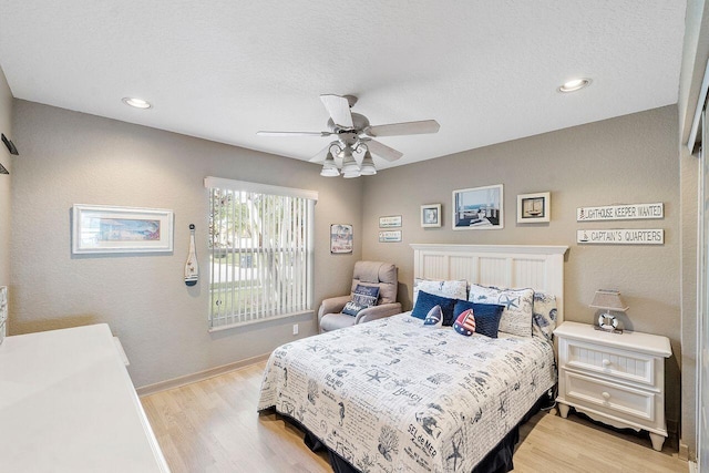 bedroom featuring ceiling fan, light wood-type flooring, and a textured ceiling