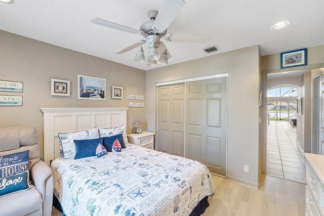 bedroom featuring ceiling fan, a closet, and light hardwood / wood-style flooring