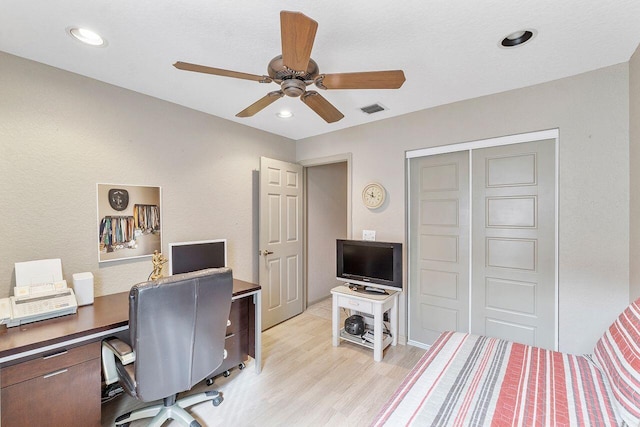 bedroom featuring light wood-type flooring, a closet, and ceiling fan